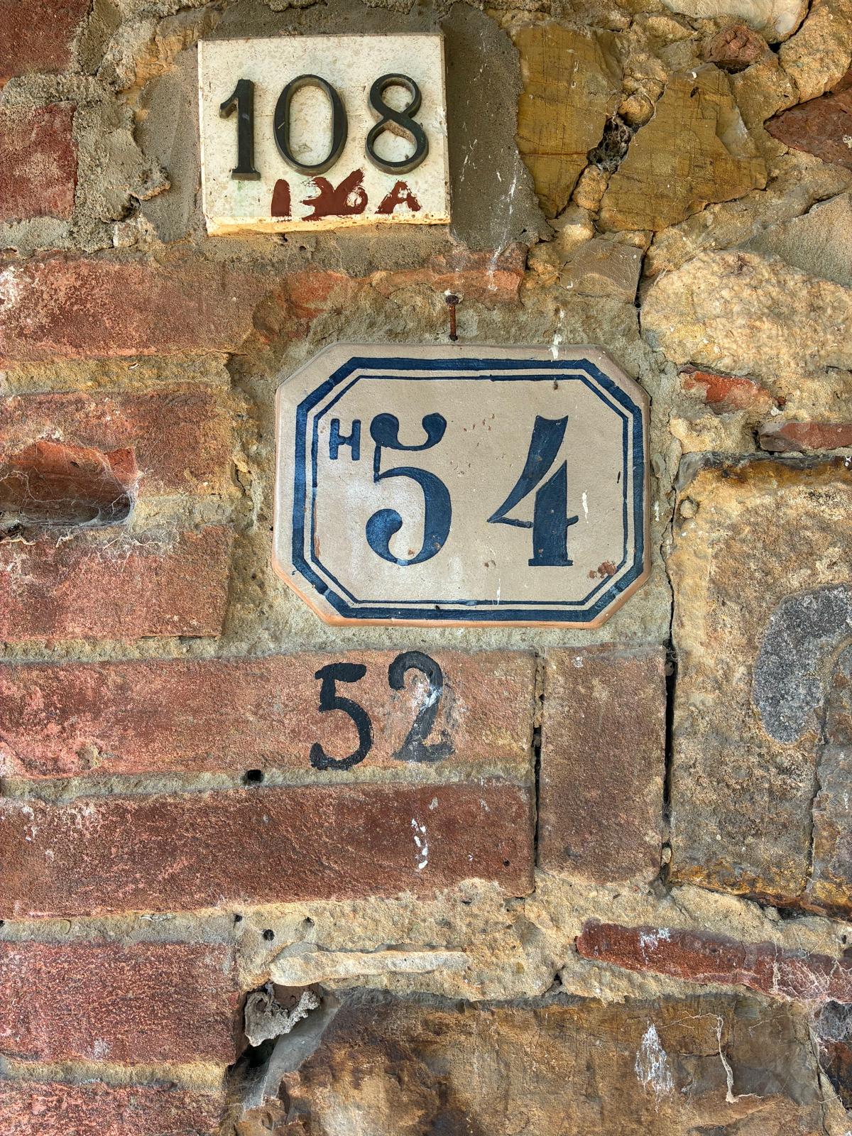 Vecchi numeri civici sulla facciata in pietra a Panicale